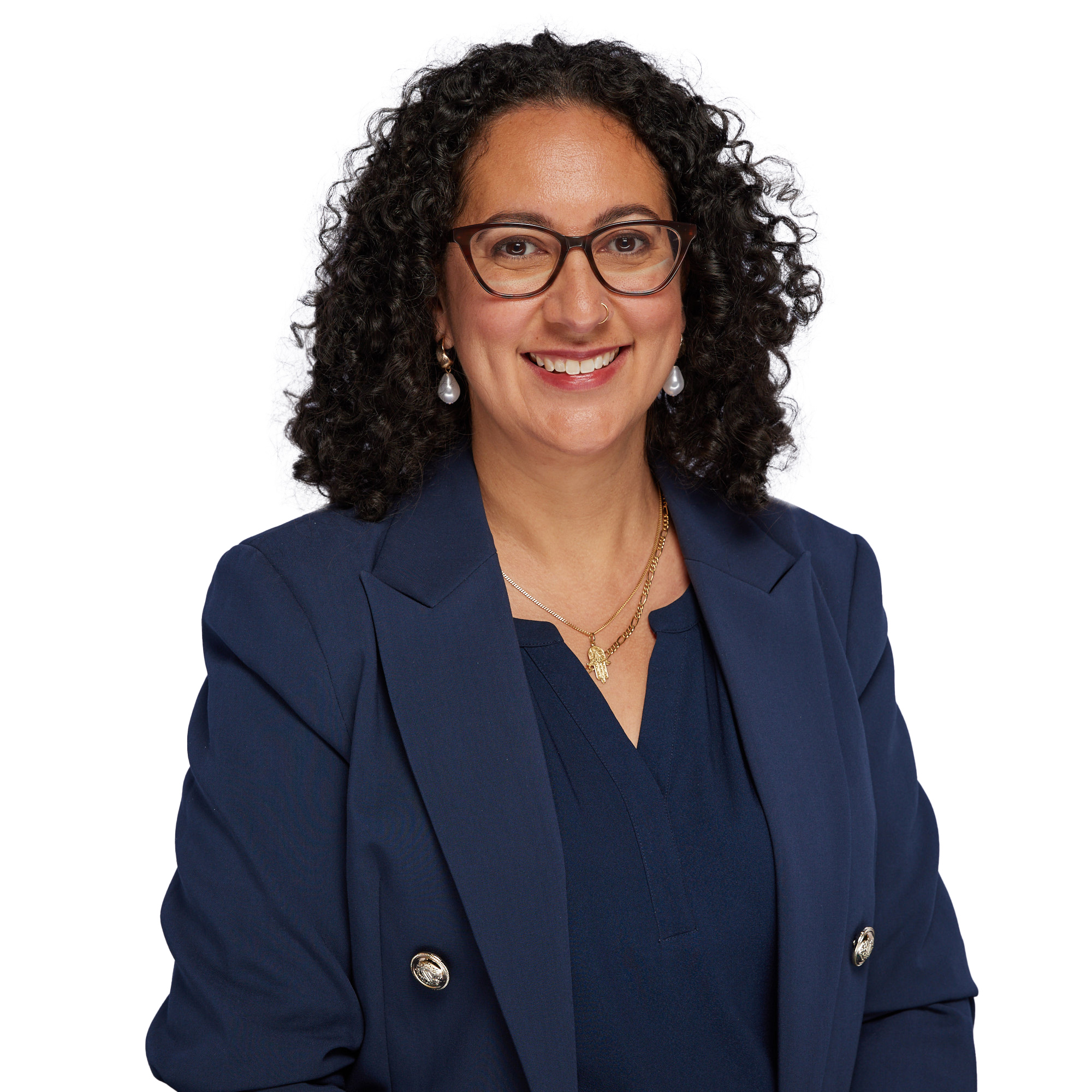 Alia Imtoual headshot - a woman smiling with dark, curly shoulder length hair wearing dark framed spectacles and a navy shirt and blazer.