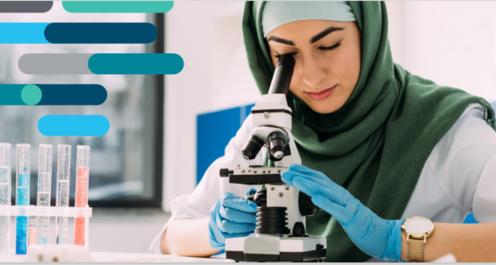 Women in a hijab using a microscope